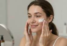 Pessoa aplicando produtos de skincare em pele oleosa, cenário de banheiro iluminado, foco em expressão de satisfação e cuidado facial