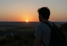 Pessoa contemplando a natureza ao pôr do sol, transmitindo sensação de presença e consciência