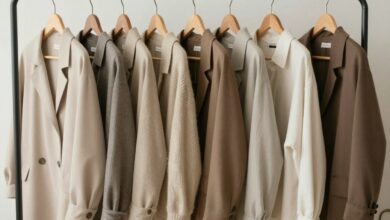 Uma mulher sorrindo enquanto organiza cuidadosamente seu guarda-roupa minimalista com peças de roupas de alta qualidade em tons neutros, simbolizando o conceito de slow fashion.