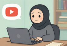 Uma figura encapuzada e anônima sentada em frente a um computador com o símbolo do YouTube brilhando na tela, representando o conceito de um canal dark.