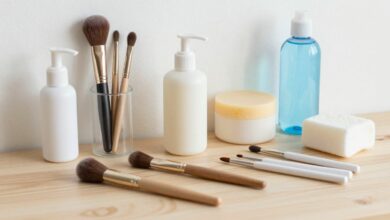 Pincéis de maquiagem limpos e organizados ao lado de sabonete suave, água e acessórios de higienização sobre uma bancada clara