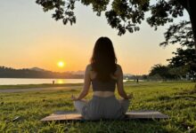 Pessoa contemplando uma paisagem ao nascer do sol, representando atenção plena, tranquilidade e a prática de viver o presente