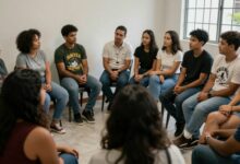 Grupo diverso de pessoas reunidas em um espaço comunitário acolhedor, conversando, colaborando e demonstrando conexão, empatia e bem-estar social