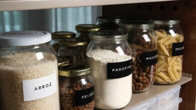 Despensa doméstica organizada com potes transparentes bem vedados contendo arroz, feijão, farinha, massas e castanhas, em ambiente seco e protegido da luz.